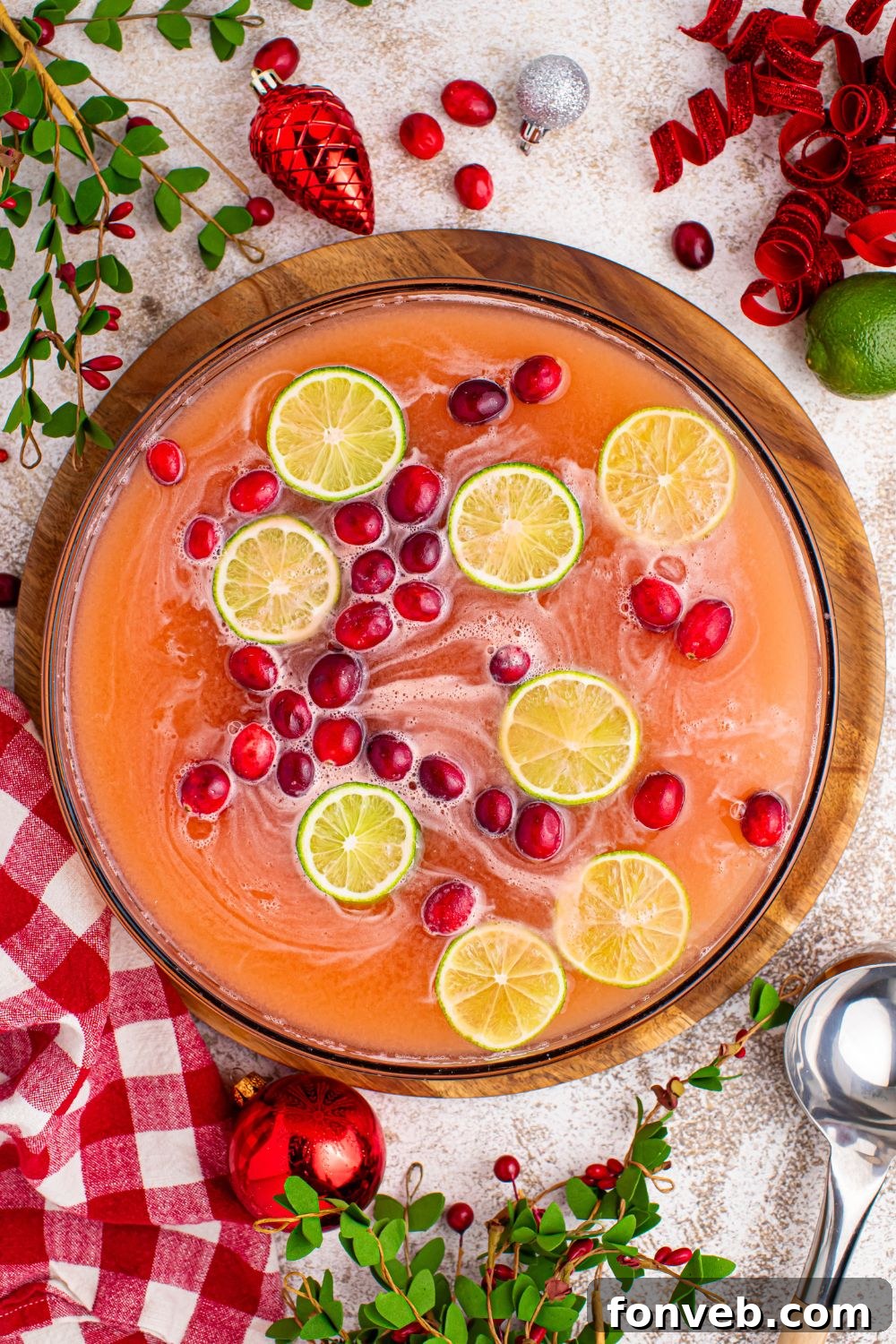 Close-up of Giggle Juice punch in a large clear punch bowl, showing the vibrant color and frothy texture, with a serving ladle.