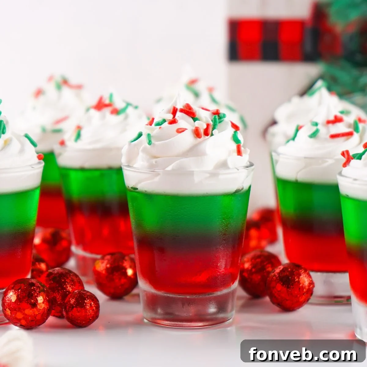Yuletide Jiggle Shots 3 Christmas Jello Shots on table with decorations around it