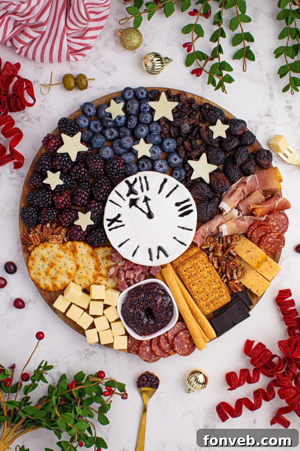 The New Year's Eve Charcuterie Board elegantly presented on a table, garnished with fresh herbs, an assortment of berries, and other decorative elements, enhancing its festive appeal.