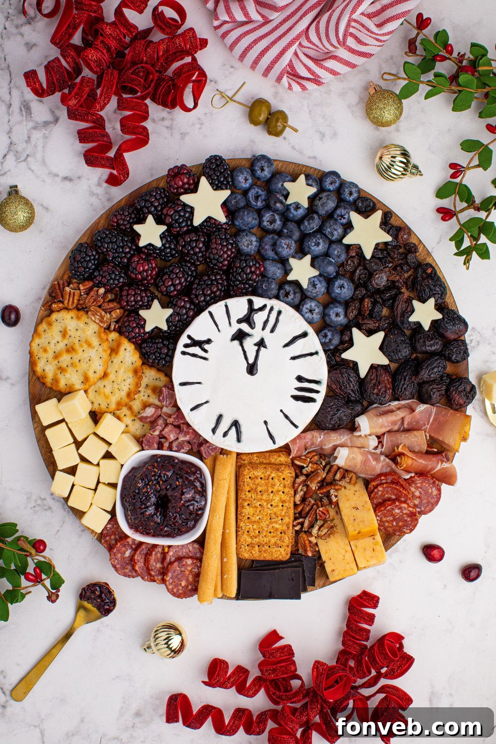 The New Year's Eve Charcuterie Board beautifully presented on a table, adorned with festive ribbon, fresh berries, and aromatic herbs, creating a charming and celebratory display.