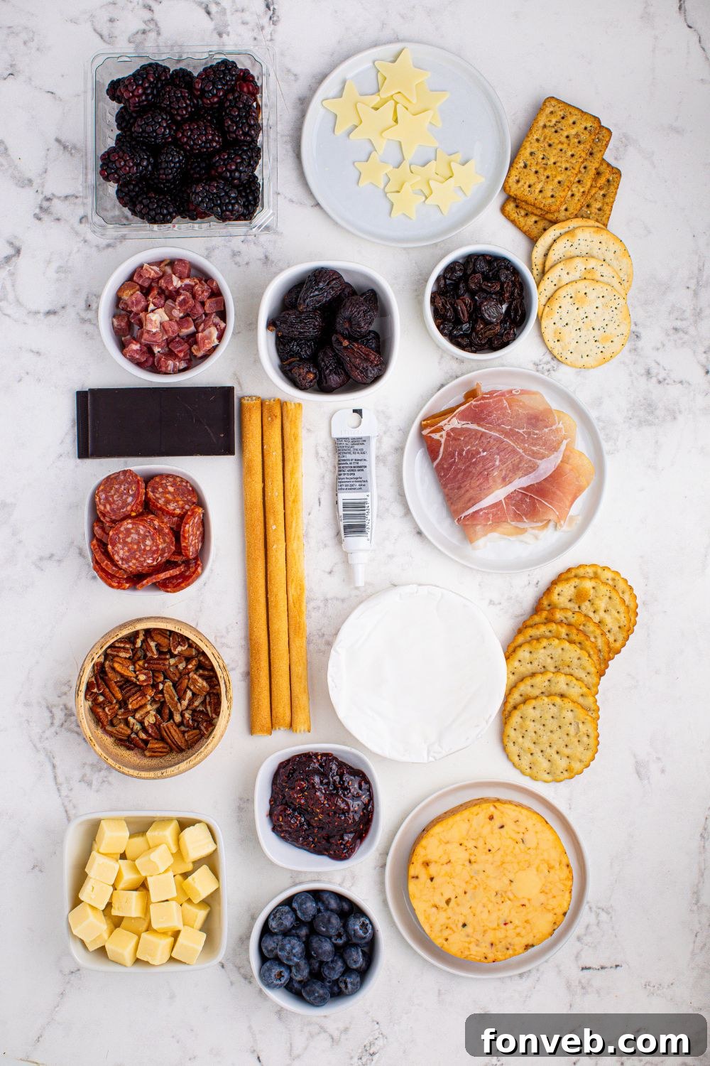 A selection of fresh ingredients for a New Year's Eve Charcuterie Board, neatly arranged in glass bowls on a table, highlighting each item for the snacking experience.