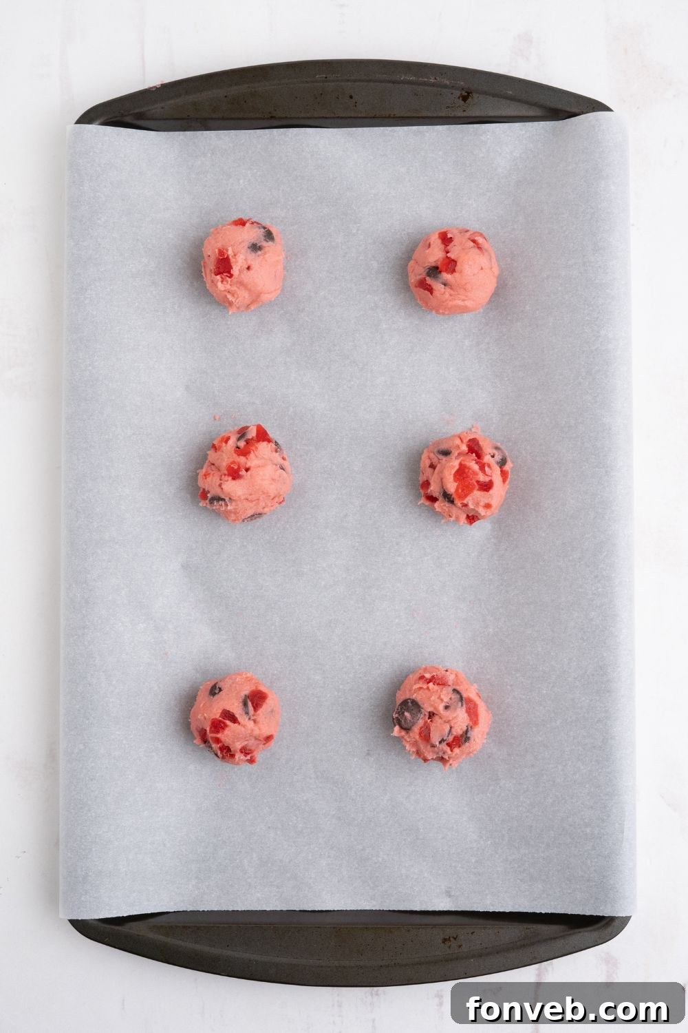 Cherry Chocolate Chip Cookie dough balls on a parchment lined pan 