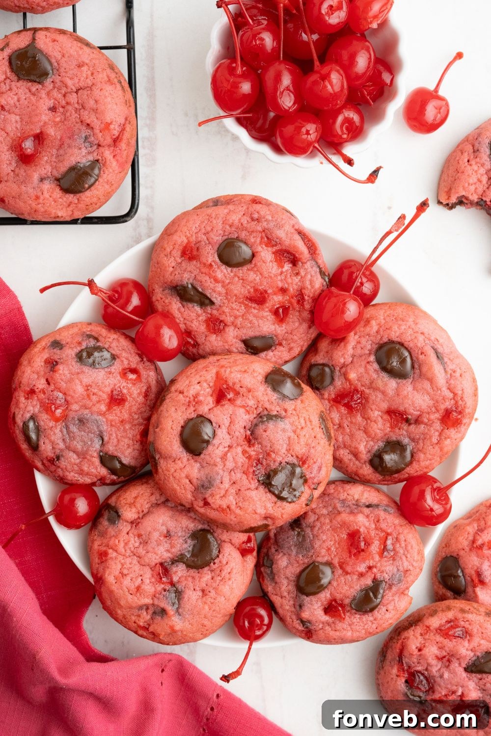overhead look of Cherry Chocolate Chip Cookies on a plate with cherries placed around the cookies 