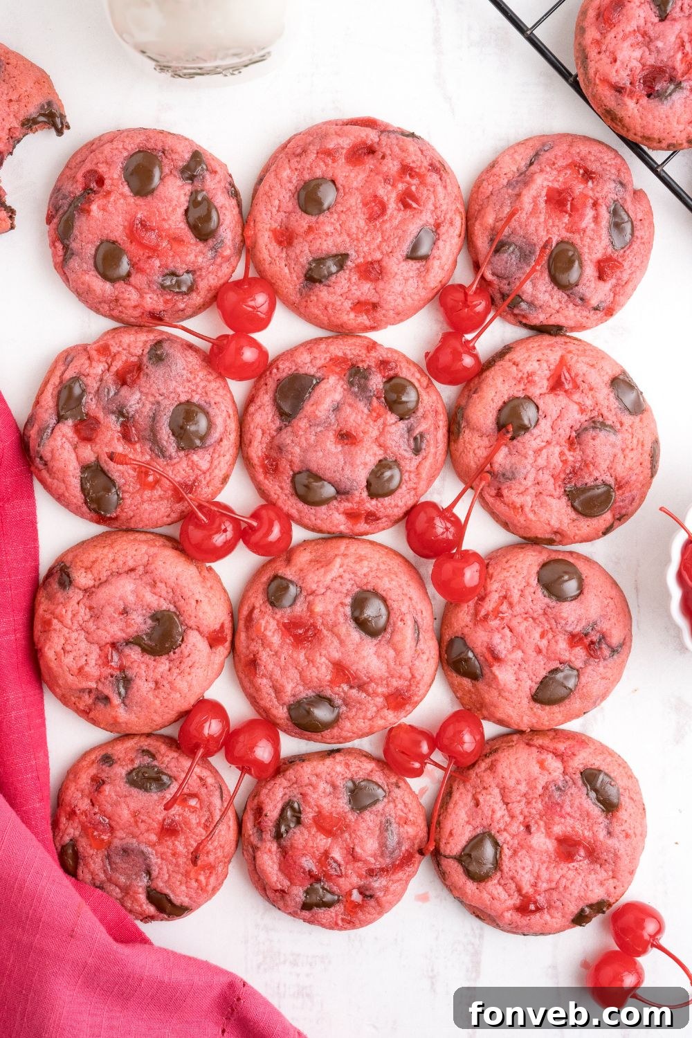 Cherry Chocolate Chip Cookies placed on the table with a towel and real cherries on the side 