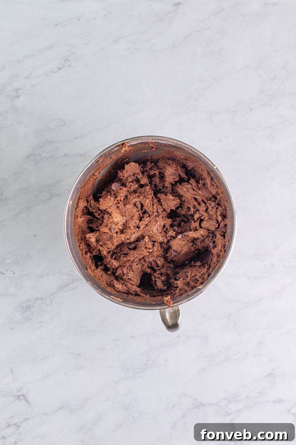 Fully mixed chocolate cake cookie batter in a stand mixer, showcasing its smooth consistency and incorporated chocolate chips