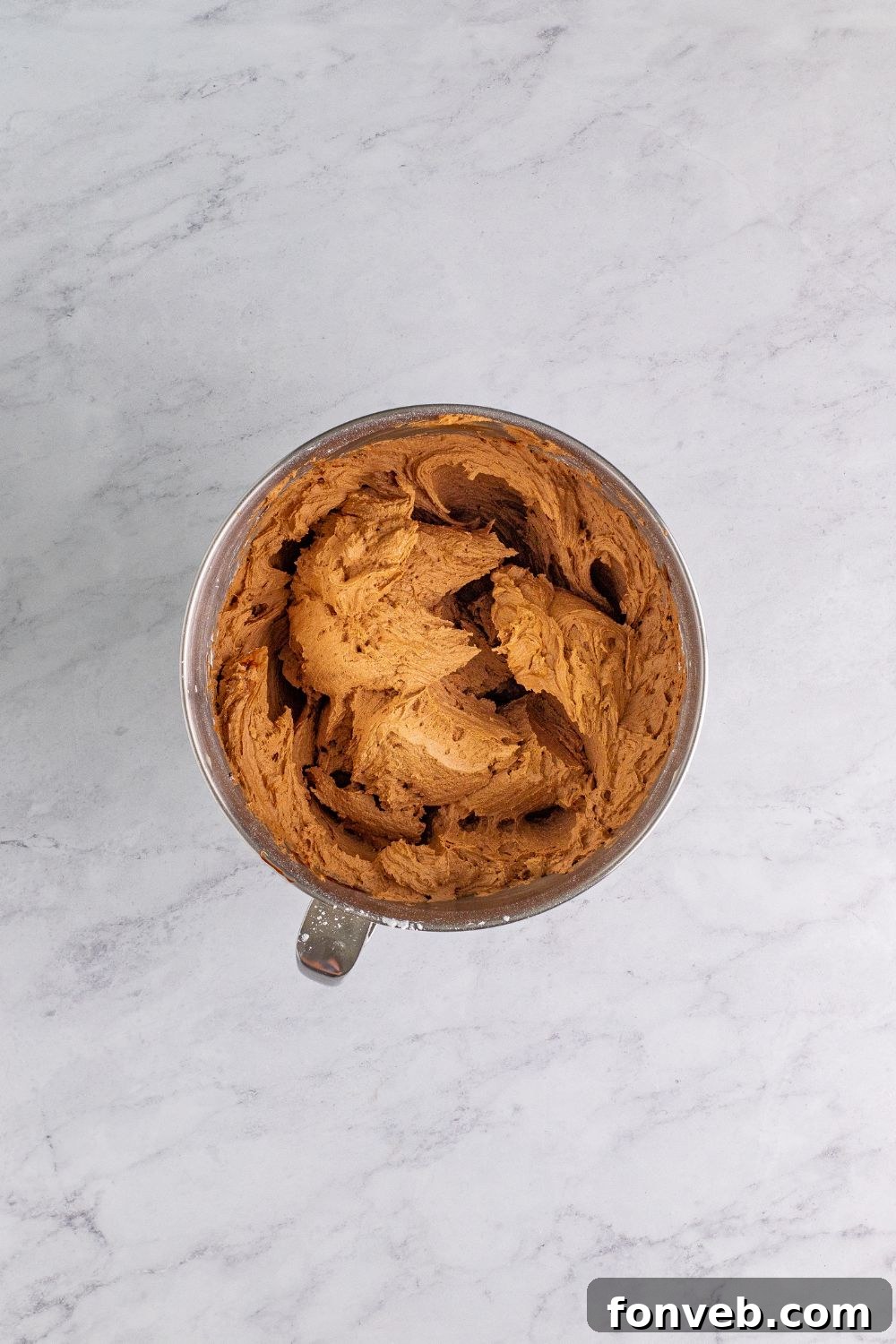 Velvety chocolate fudge frosting being whipped to perfection in a stand mixer, ready to top the Chocolate Cake Cookies