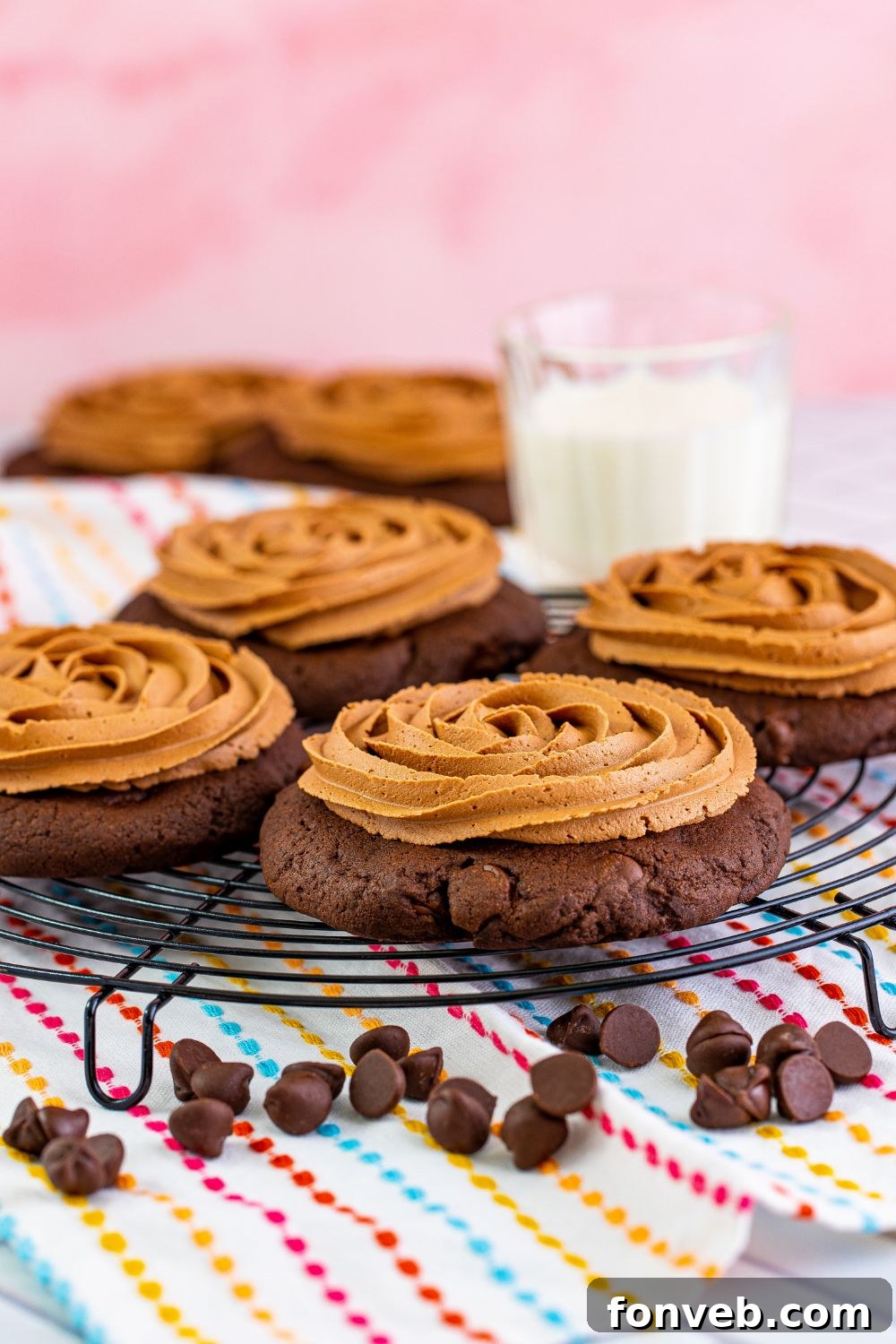 A tray of frosted Chocolate Cake Cookies with a glass of milk in the background, inviting a delicious treat