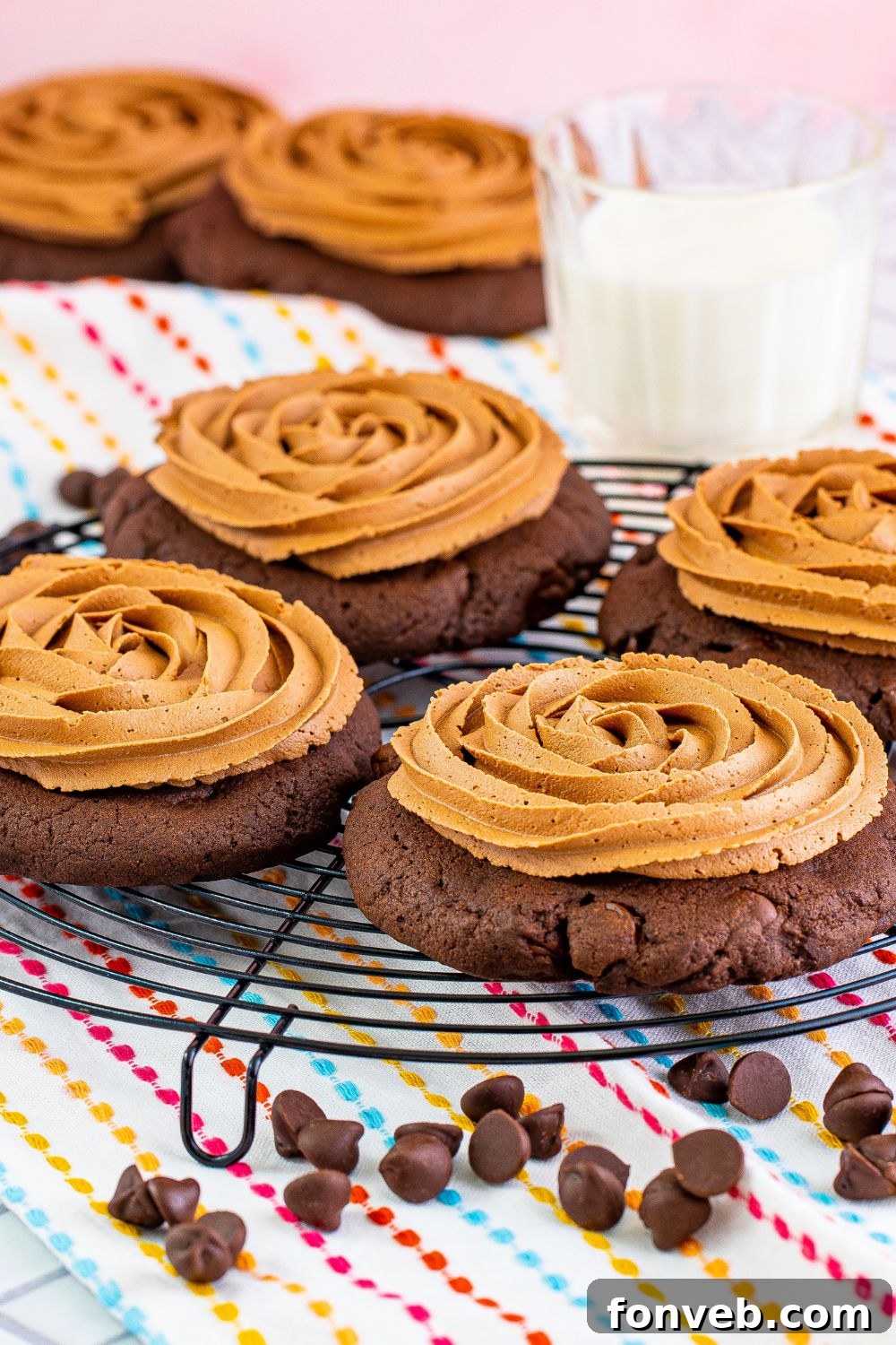 Round tray filled with frosted Chocolate Cake Cookies, with a small bowl of chocolate chips scattered in front