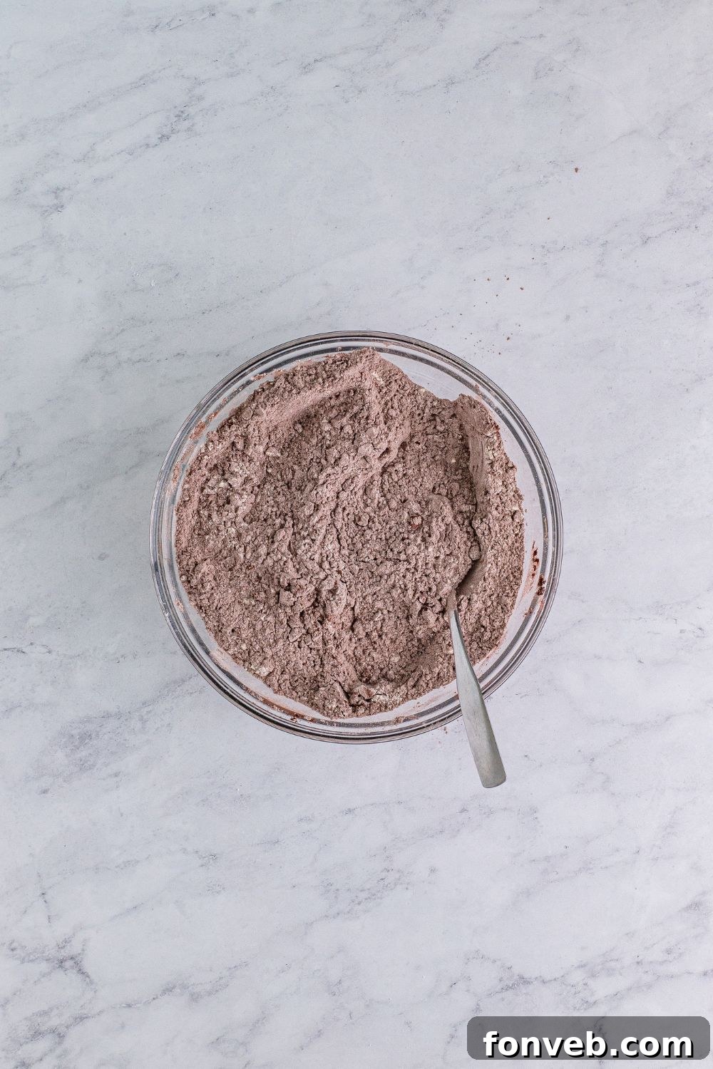Well-mixed dry ingredients for Chocolate Cake Cookies, showing a uniform blend of flour and cocoa powder in a glass bowl