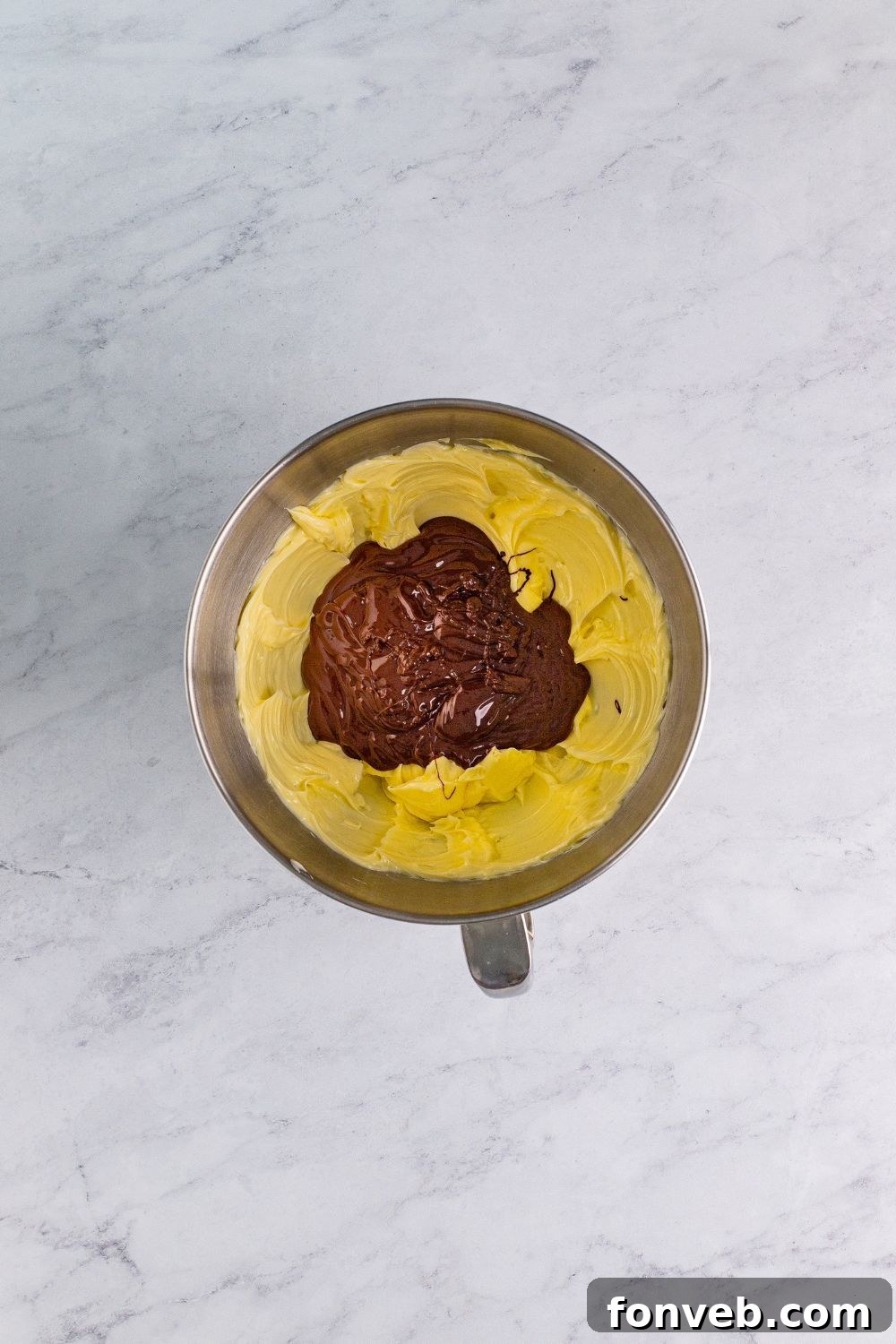 Rich chocolate cake cookie batter in a mixing bowl, studded with semi-sweet chocolate chips, ready for baking