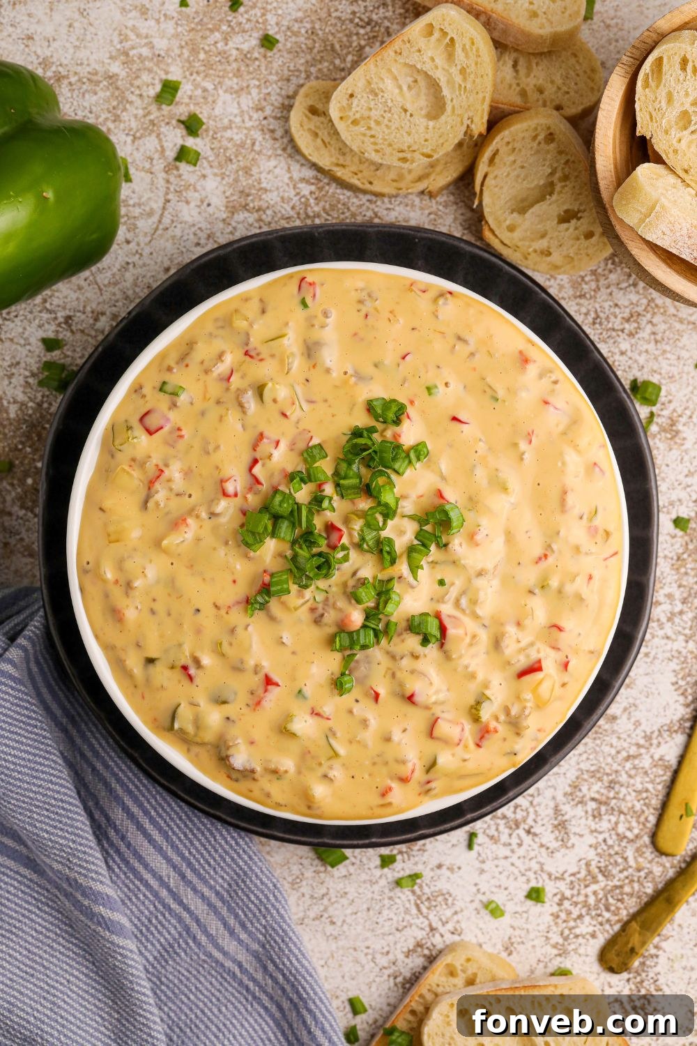 Crock Pot Philly Cheesesteak Dip in a bowl with some green garnish on top