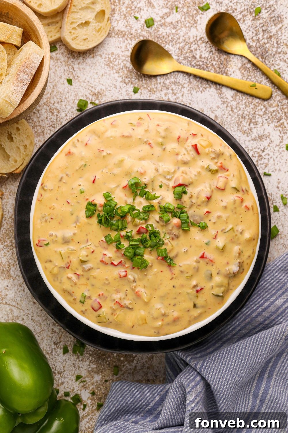 Crock Pot Philly Cheesesteak Dip in a black bowl with sliced bread and a towel around the bowl on counter