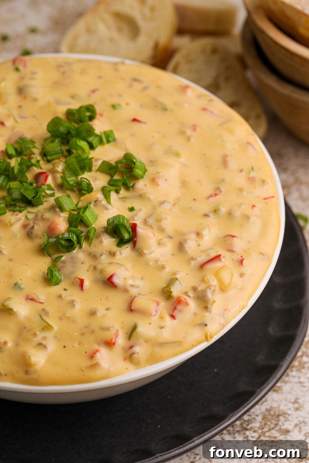 Crock Pot Philly Cheesesteak Dip in a white bowl on table with garnish on top