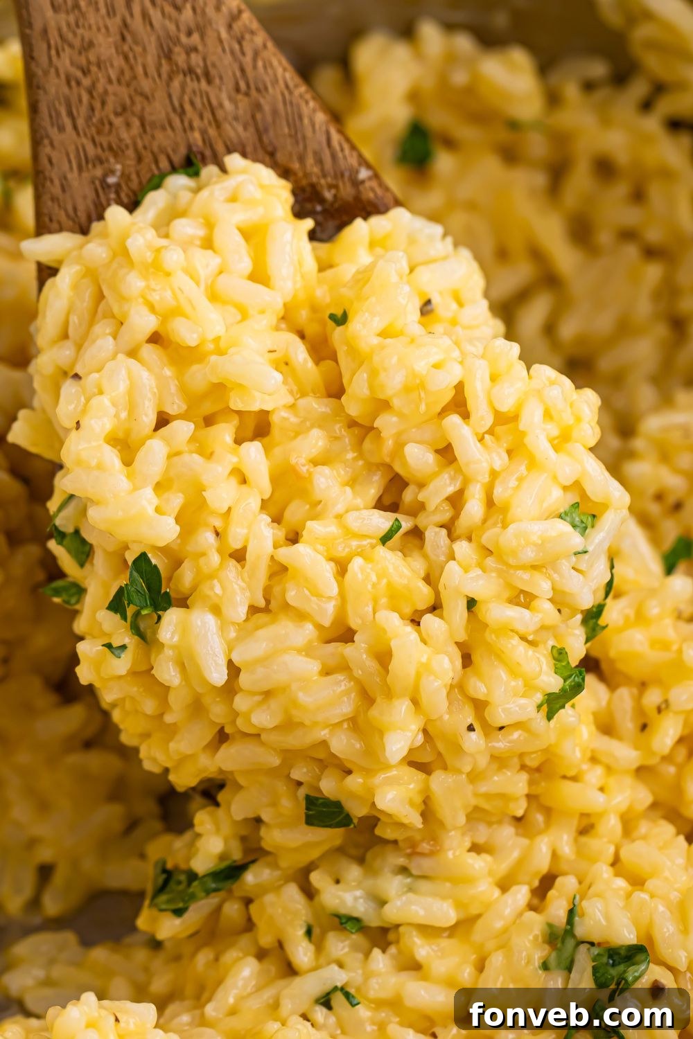 A wooden spatula scooping perfectly cooked Souper Rice from the pan.