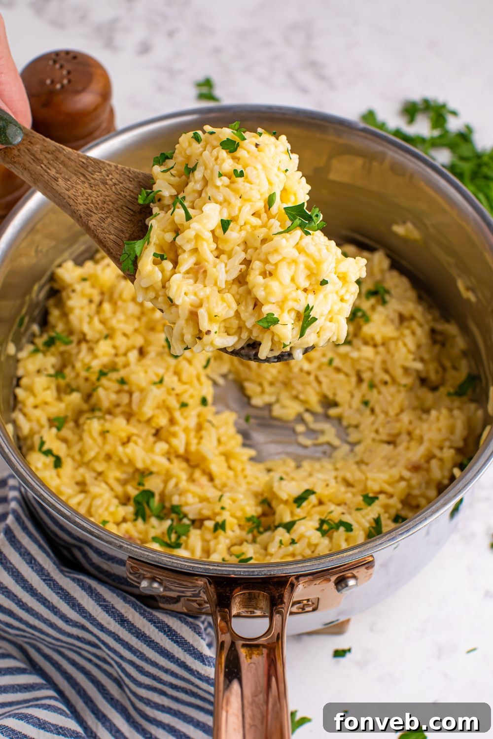 Souper Rice being stirred with a wooden spoon in a pan.