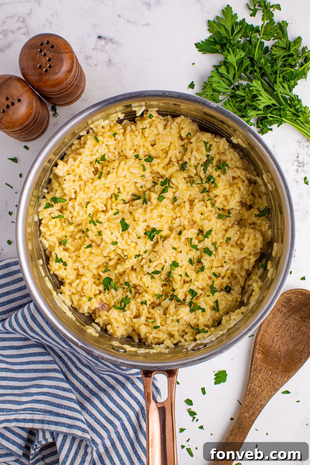 A spread of Souper Rice in a pan with salt, pepper, and parsley, ready for serving.