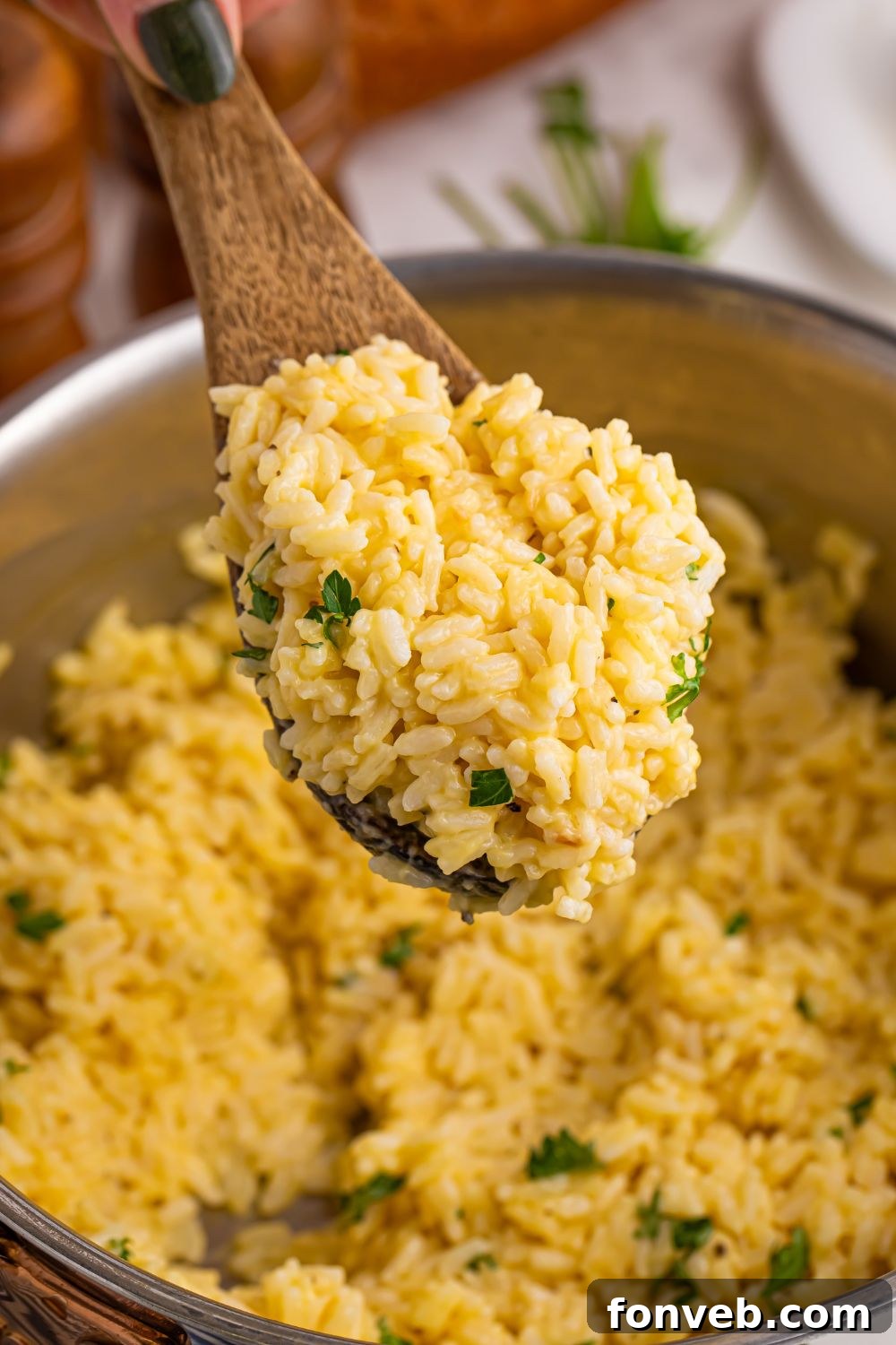 Souper Rice simmering in a pan with a wooden spoon, showcasing its creamy texture.