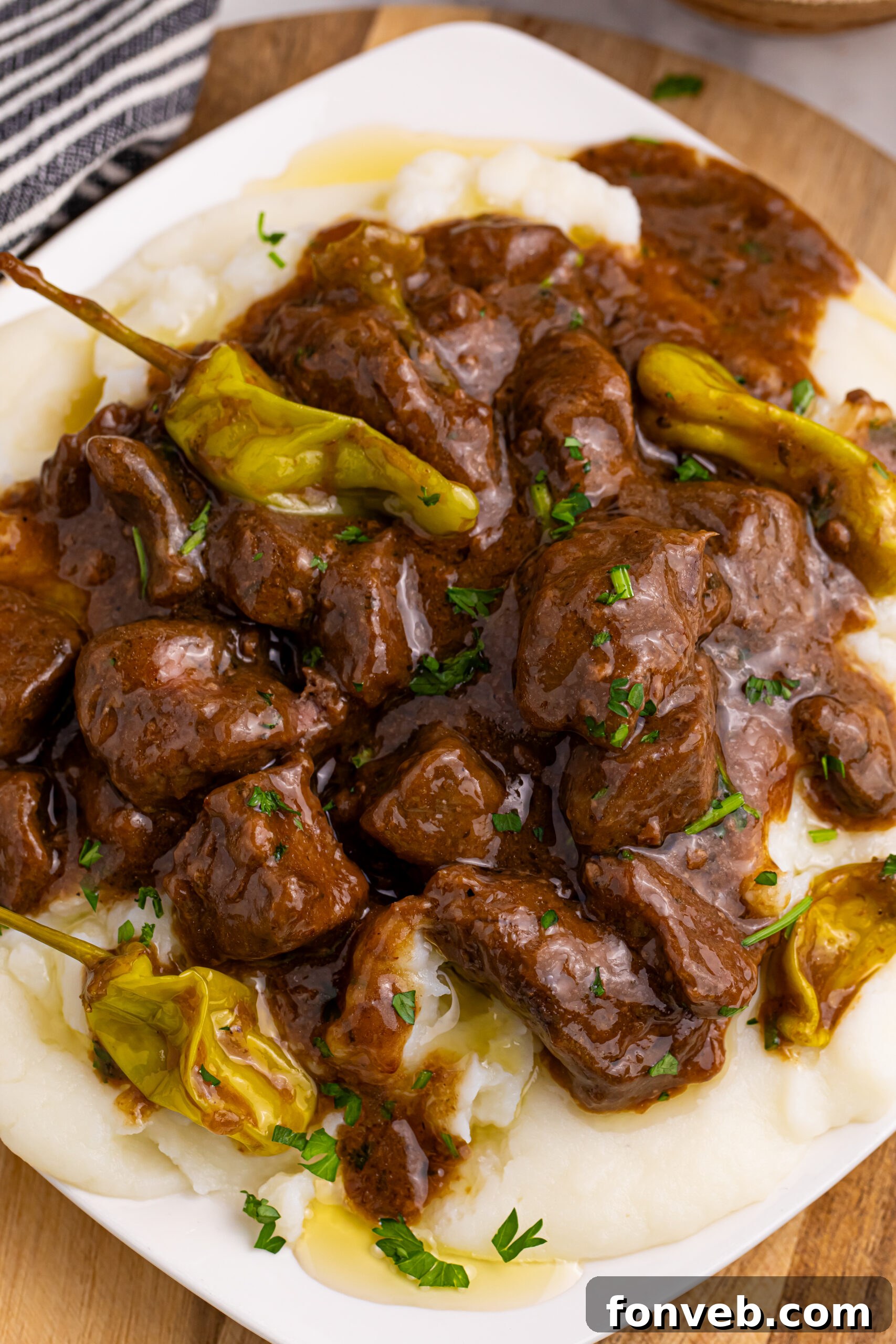 Tender Mississippi Crockpot Steak Bites 2 Tender Slow Cooker Mississippi Steak Bites served over creamy mashed potatoes, garnished with fresh parsley.