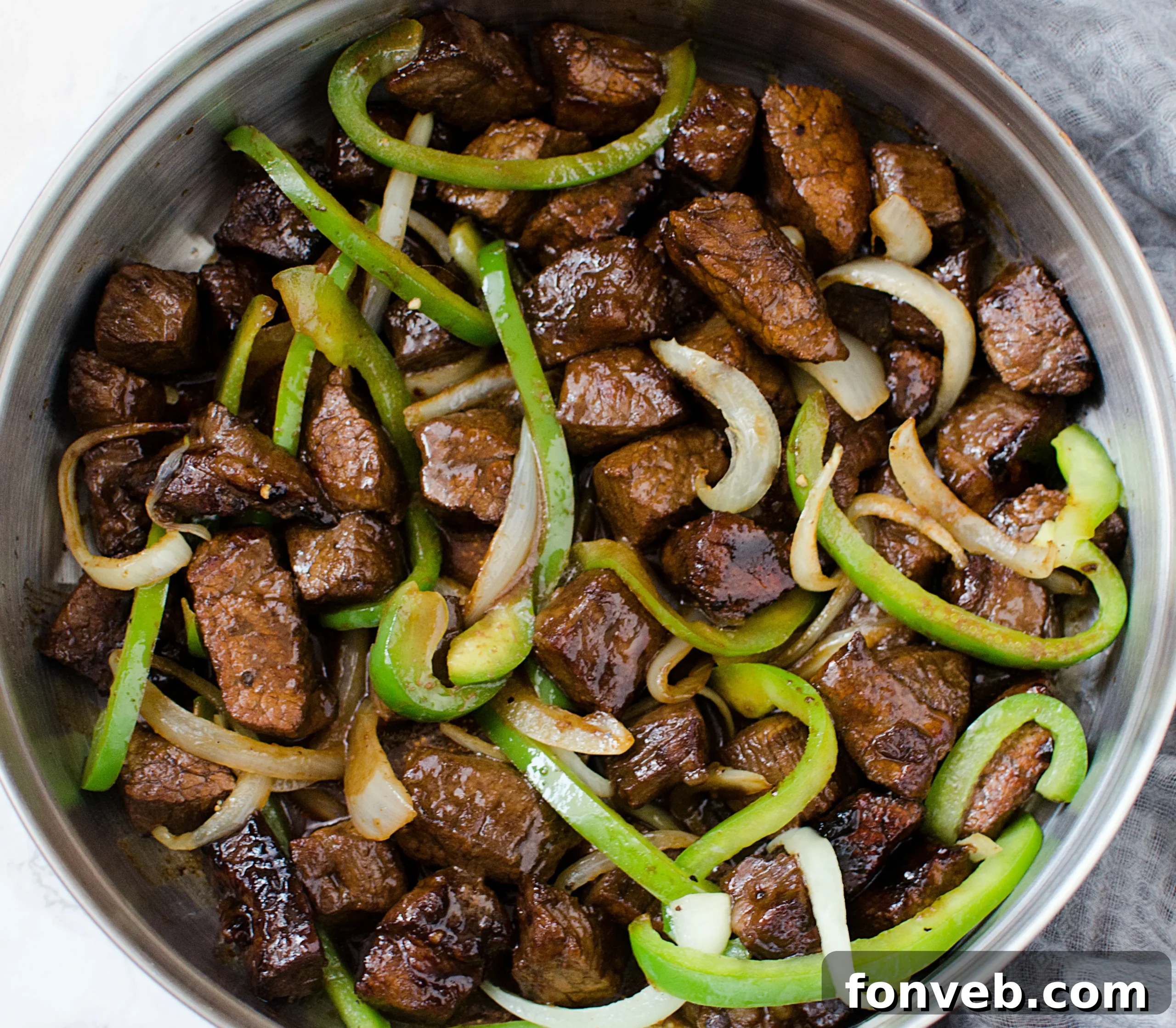 Delicious Asian steak with peppers and onions served over fluffy white rice