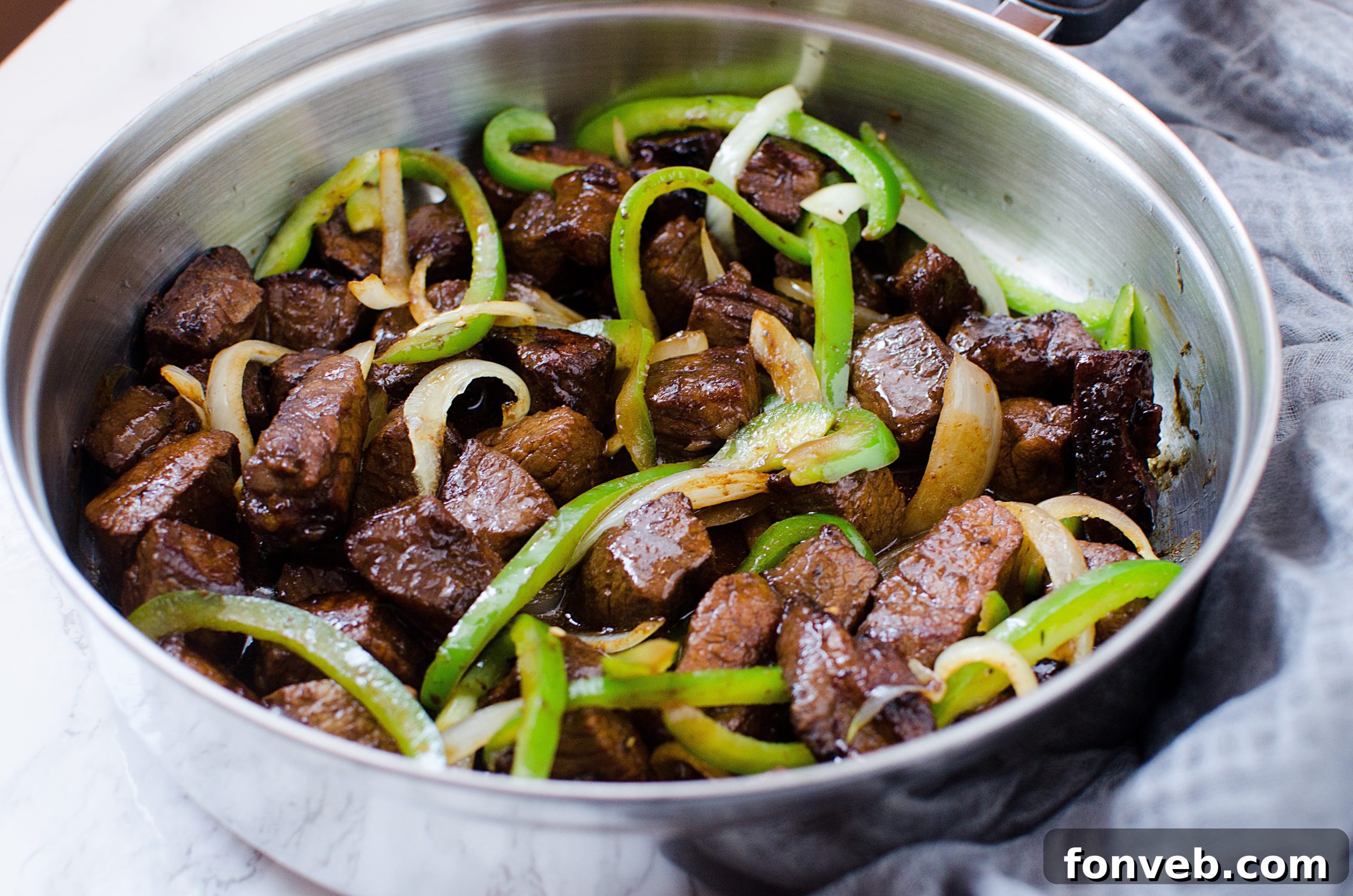 Sautéing onions and bell peppers in a large pan