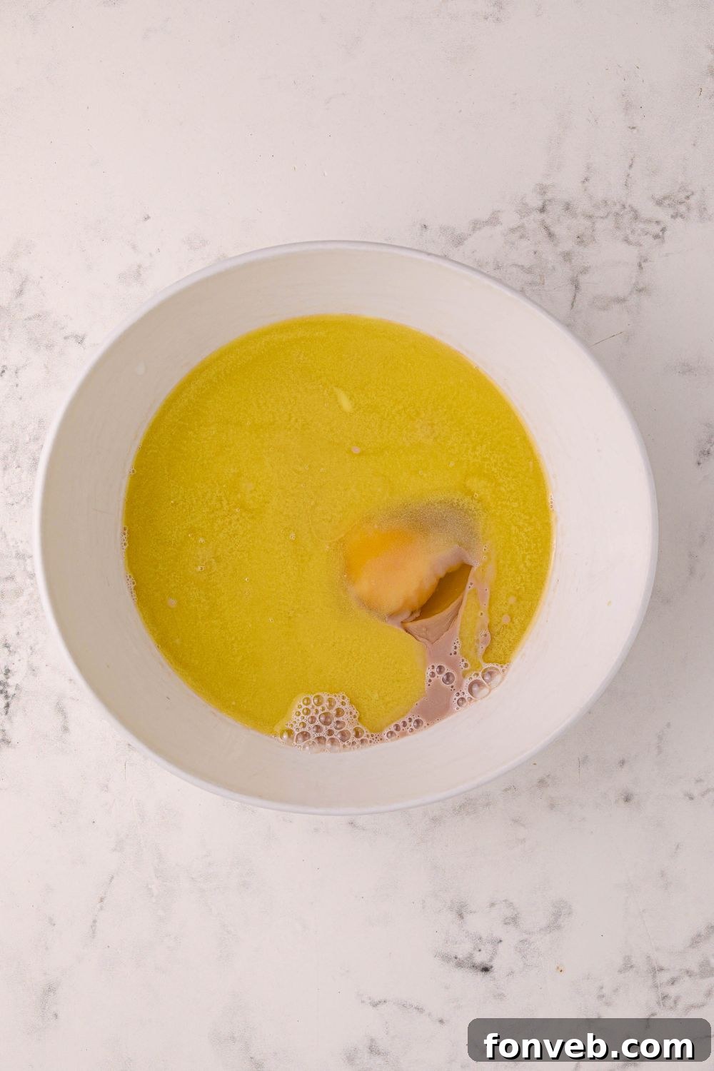 Decadent Hot Chocolate Pancakes 7 butter and egg in a mixing bowl on the table for Hot Chocolate Pancakes