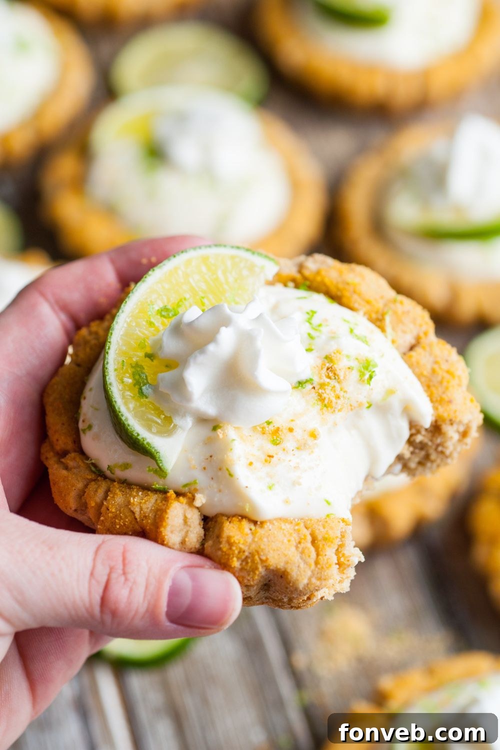 Tangy Key Lime Pie Cookies 19 Crumbl Key Lime Pie Cookie being held in hand with a small bite taken out of the cookie