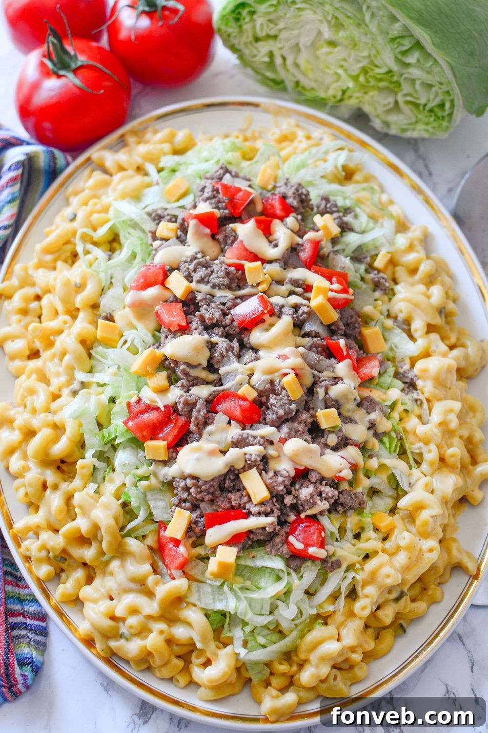 Big Mac Macaroni And Cheese in an oval platter with tomatoes and lettuce around it on table 