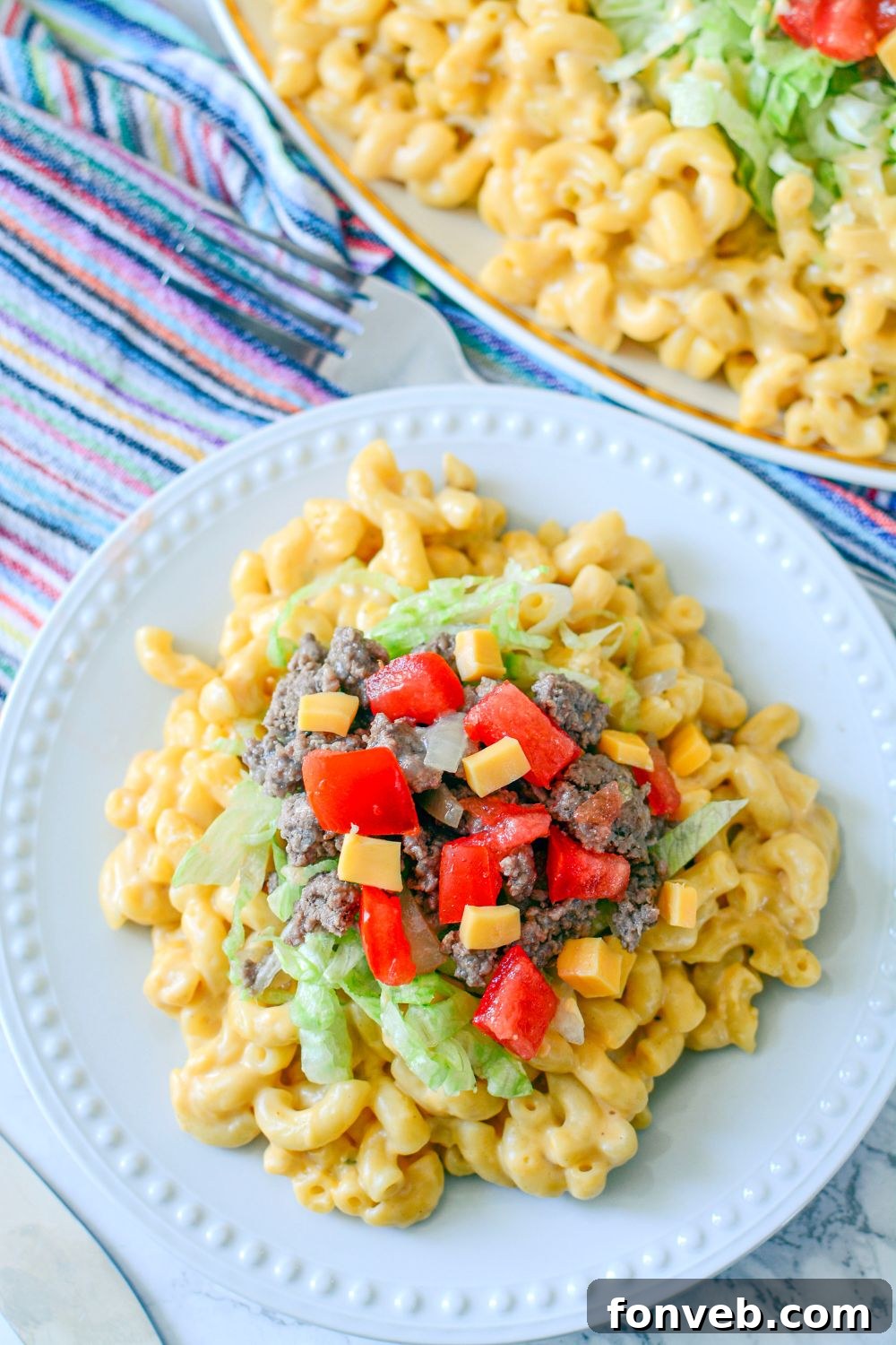 Big Mac Macaroni And Cheese on a plate with a pan of it behind it 
