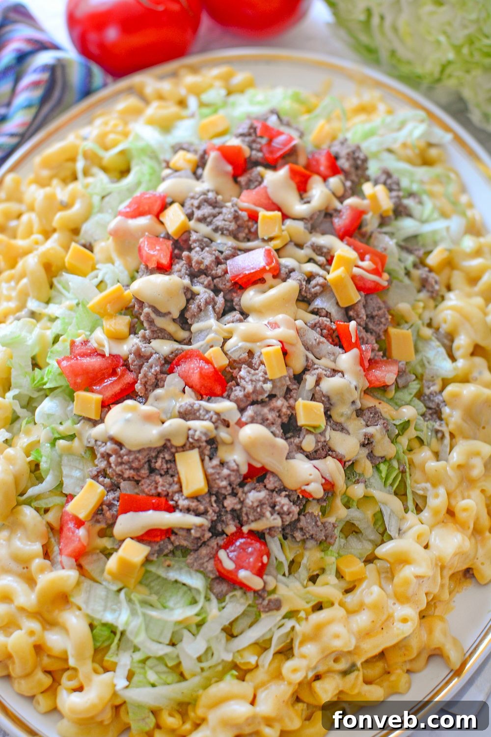 Big Mac Macaroni And Cheese on a platter with tomatoes and towel behind the platter 