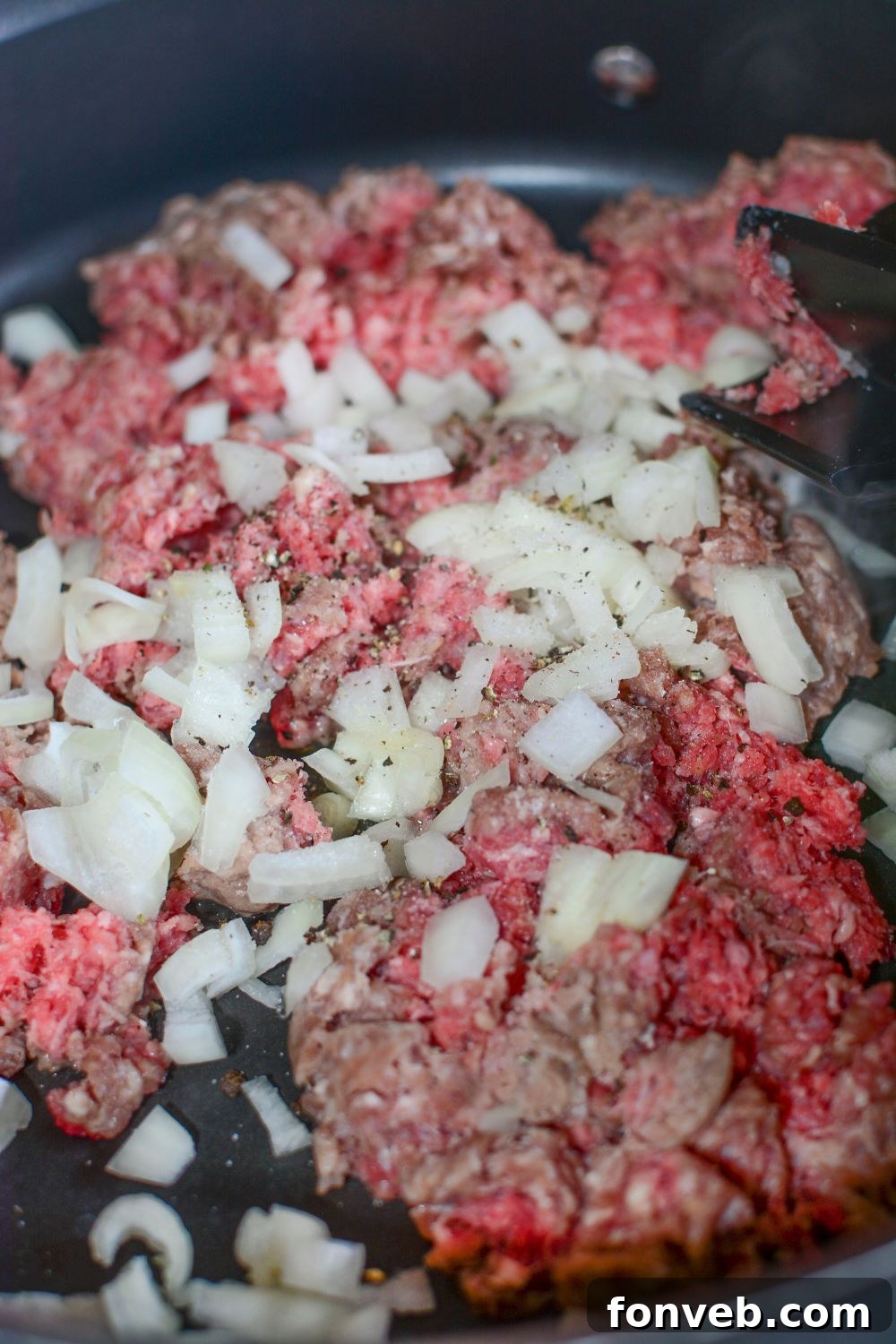 Big Mac Macaroni And Cheese hamburger an onion in a skillet on the stovetop