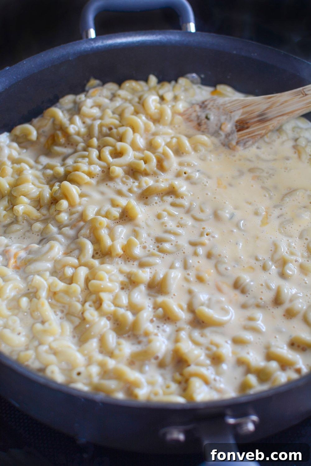 Big Mac Macaroni And Cheese mixture in a pan, it is the macaroni and cheese in a pan on stovetop 