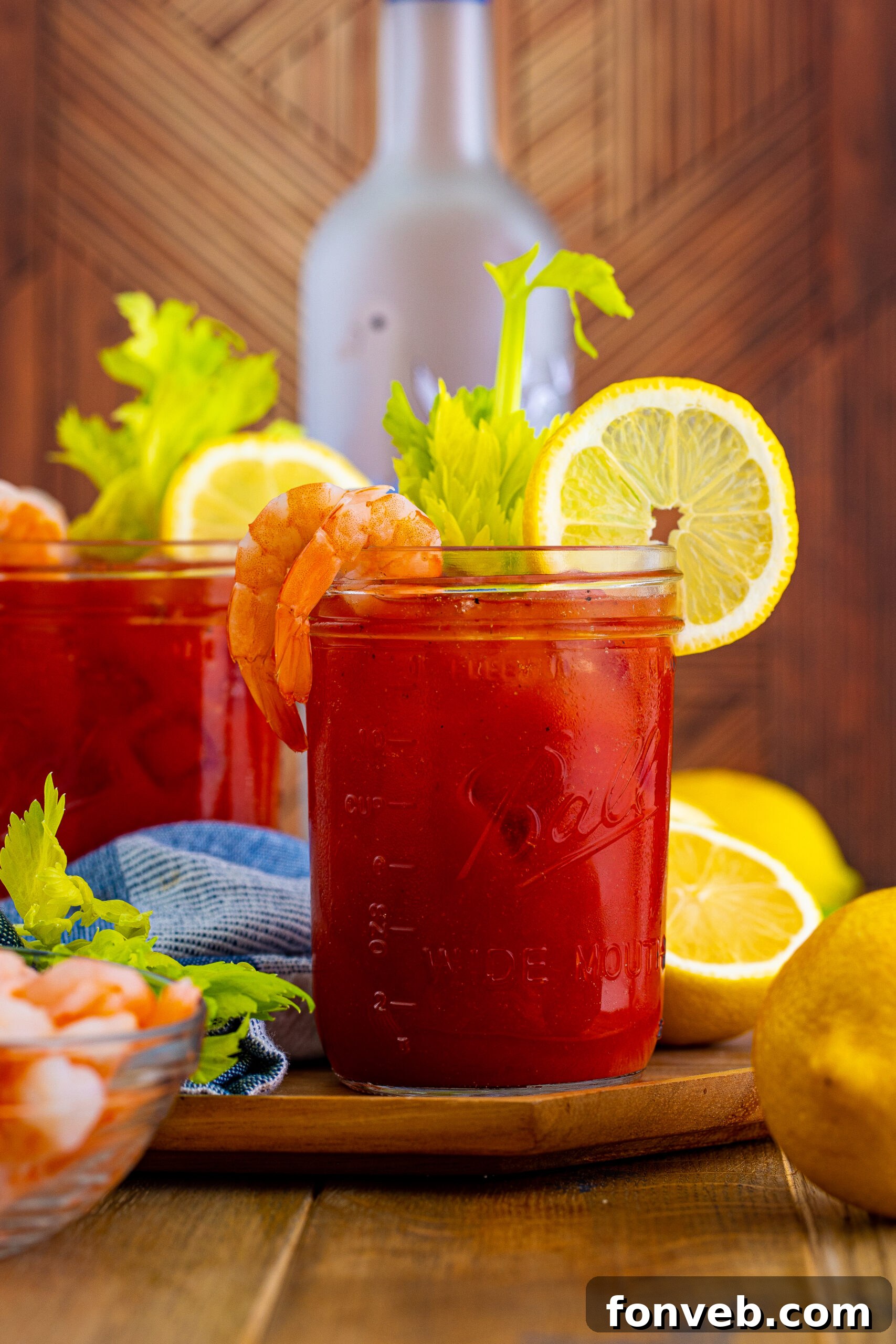 Bloody Mary drinks on table with a glass vodka bottle in background 