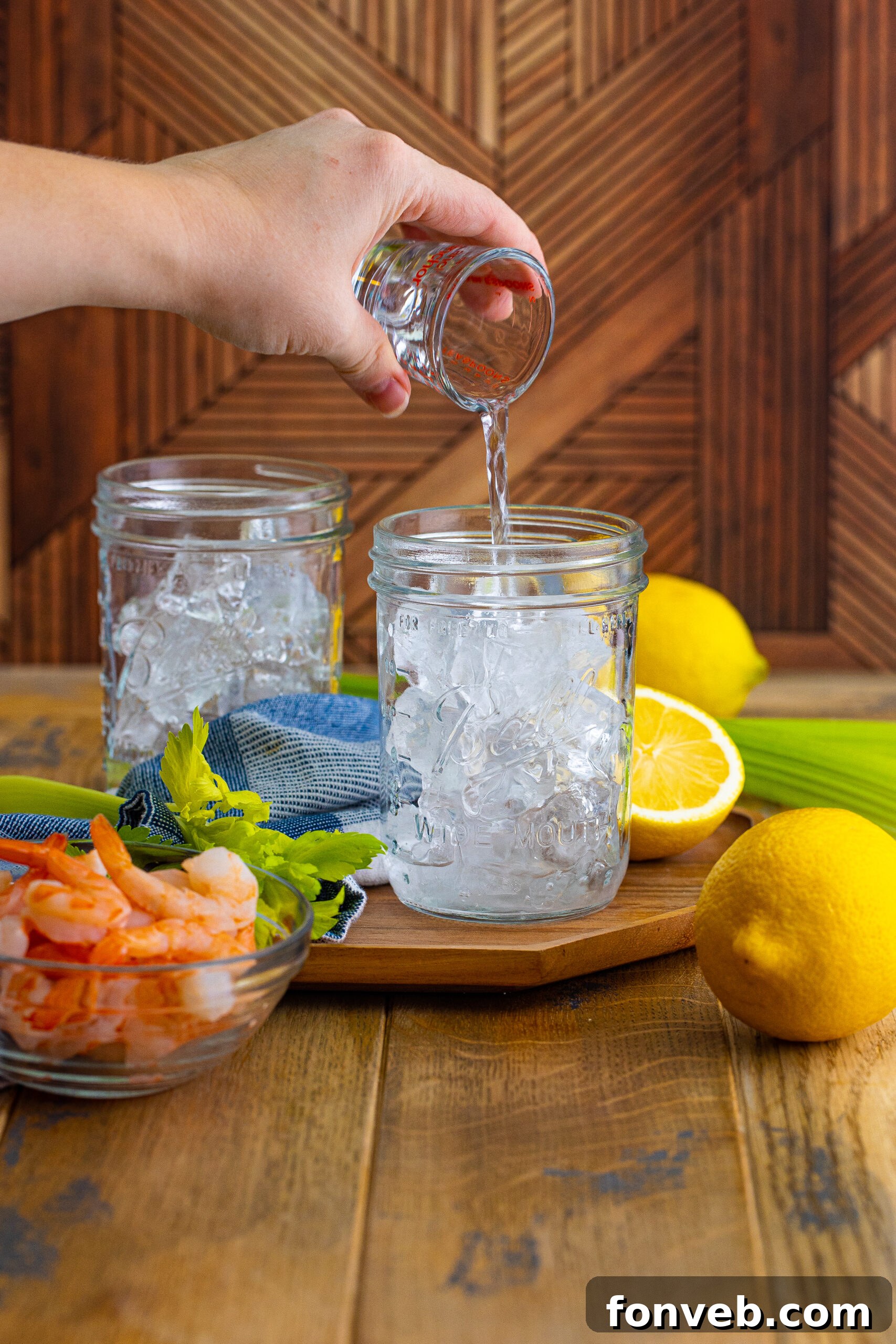 Bloody Mary drink with vodka pouring into the ice 