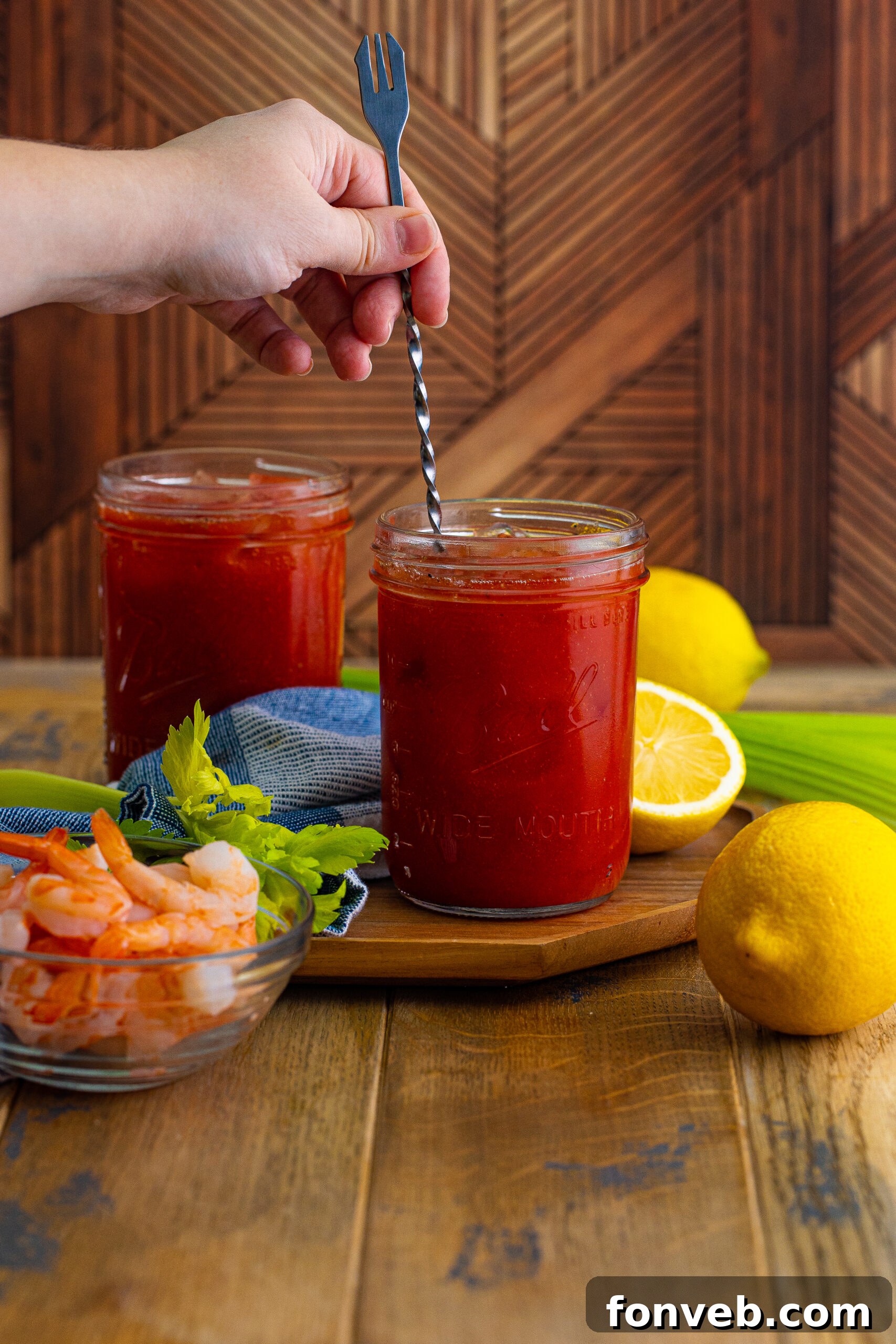 Bloody Mary being stirred in a glass with a stir stick 