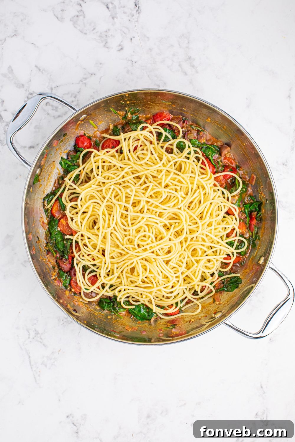spaghetti tossed in pan for making Greek Spaghetti