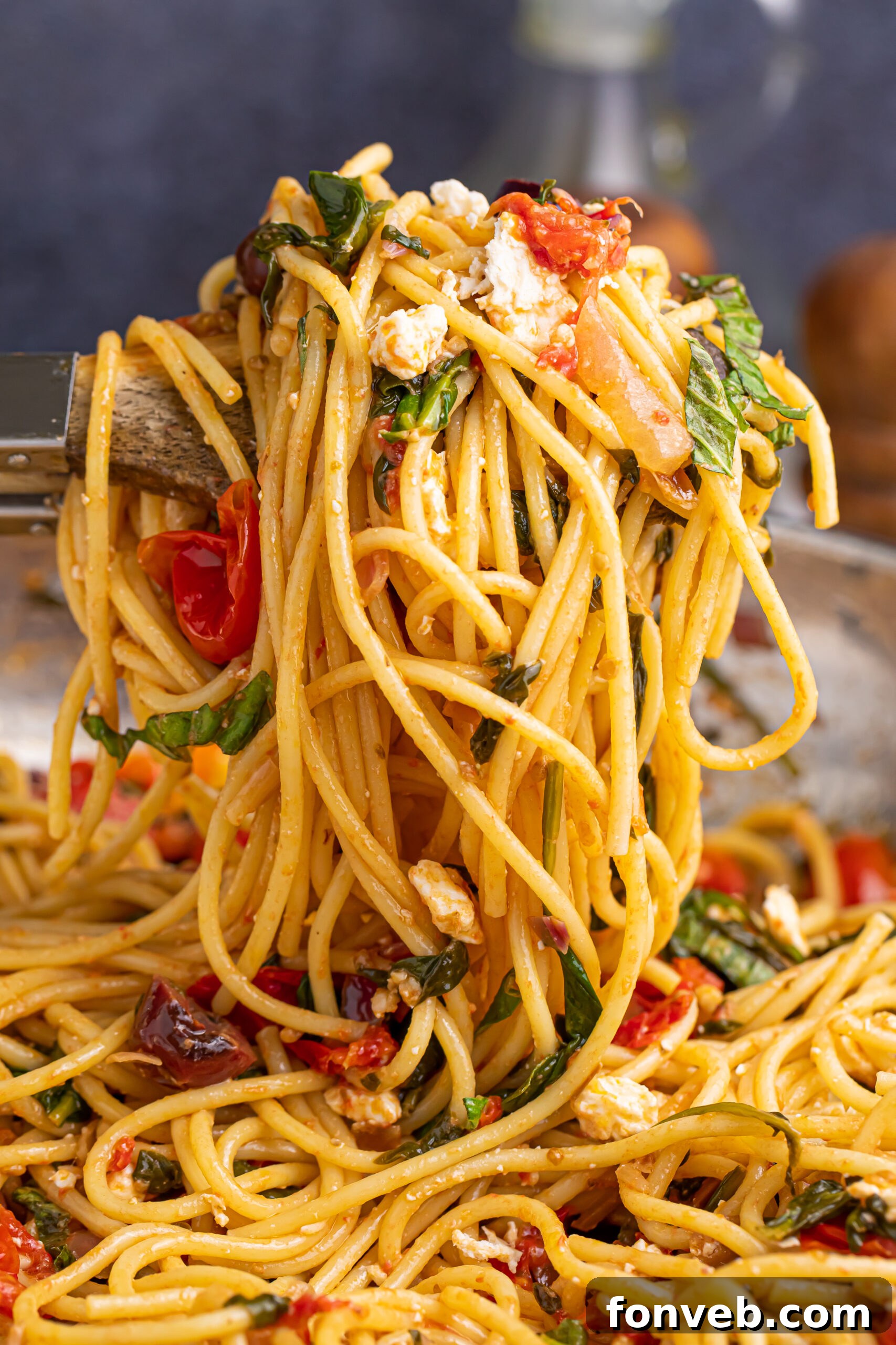 Greek Spaghetti being lifted up by a spoon, demonstrating the perfect blend of pasta and vegetables.