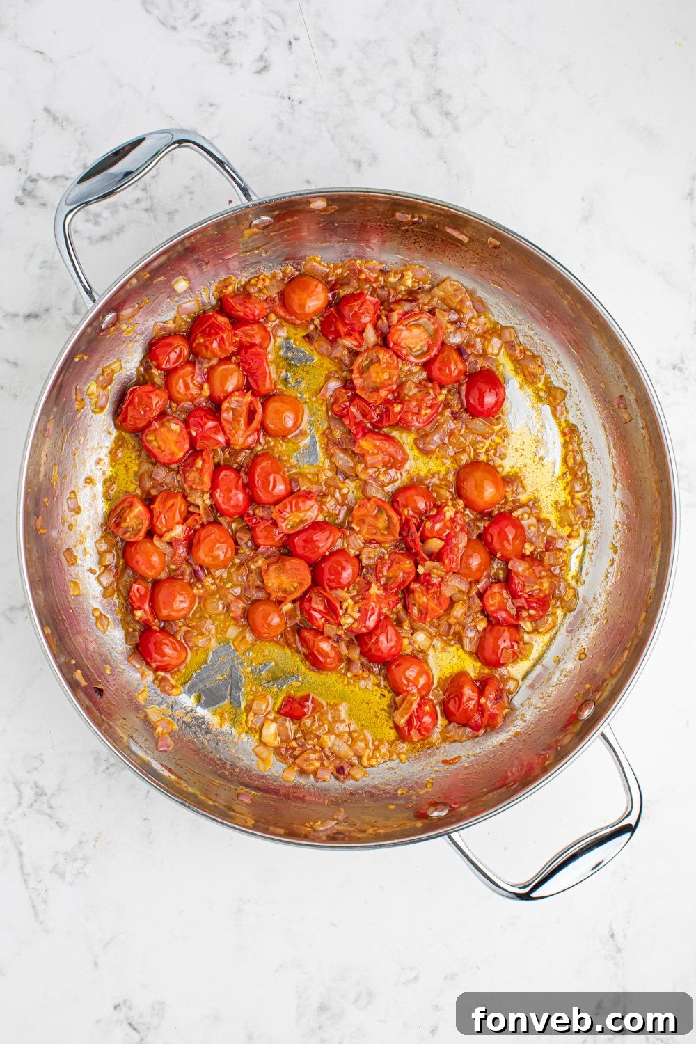 Greek Spaghetti roasted tomatoes in a pan on table with a little oil in it.