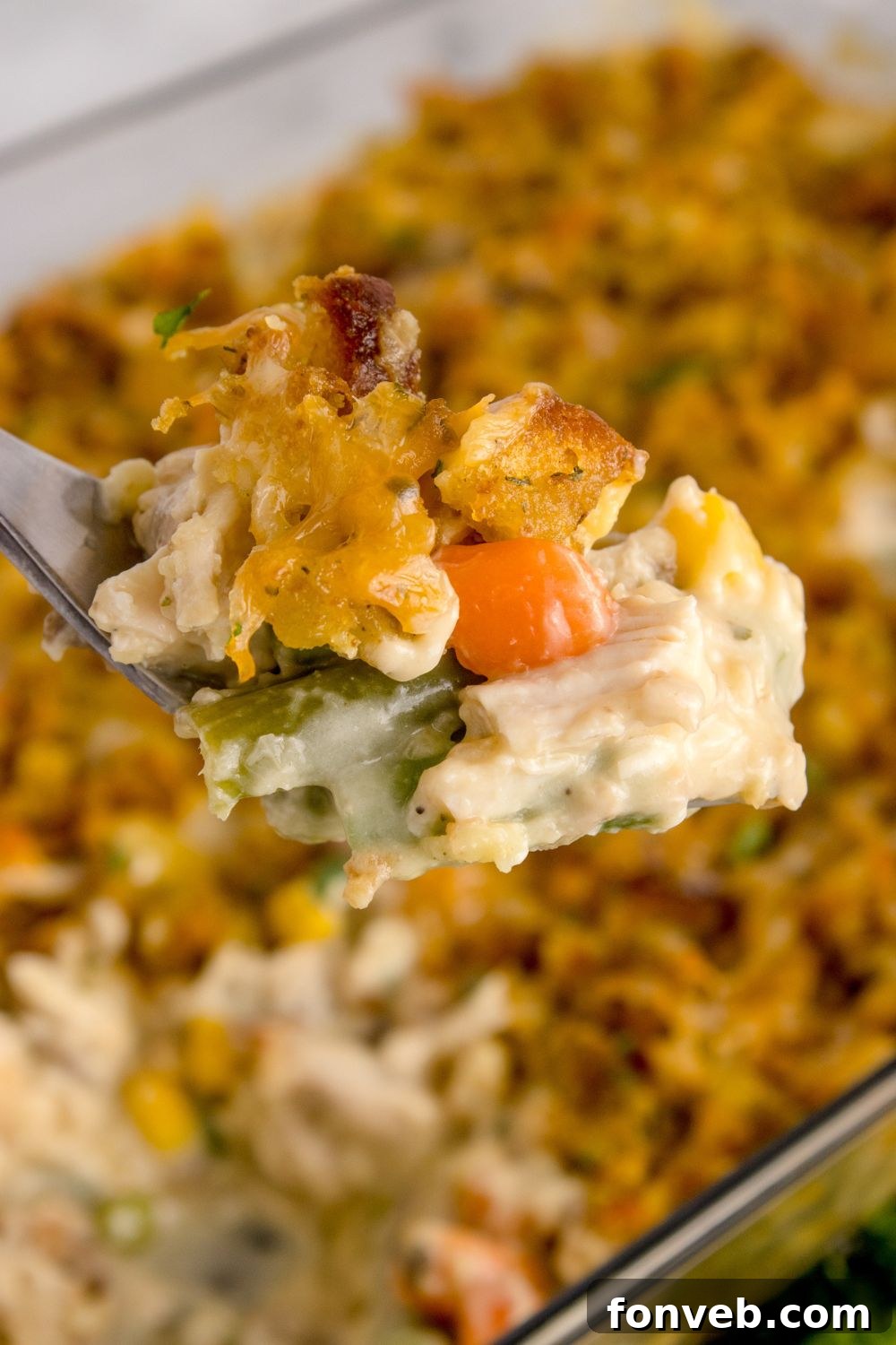 Savory Chicken Stuffing Bake 11 Chicken Stuffing Casserole in pan with a metal pan scooping out the mixture