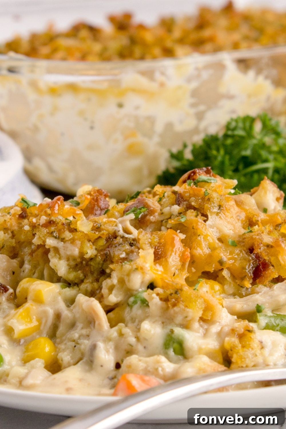Savory Chicken Stuffing Bake 12 Chicken Stuffing Casserole on plate with a close up of pan behind it on table