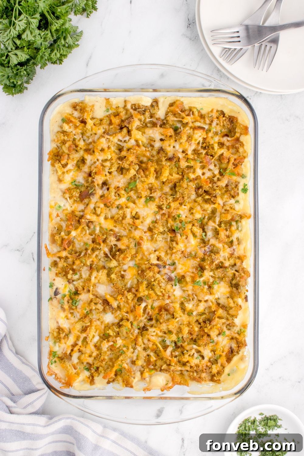 Savory Chicken Stuffing Bake 15 Chicken Stuffing Casserole on table in a glass casserole dish with fresh parsely around the pan on table
