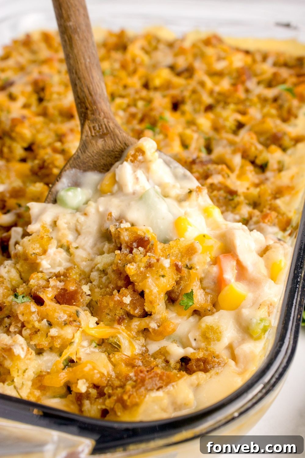 Savory Chicken Stuffing Bake 16 Chicken Stuffing Casserole with a scoop being lifted out of the casserole dish