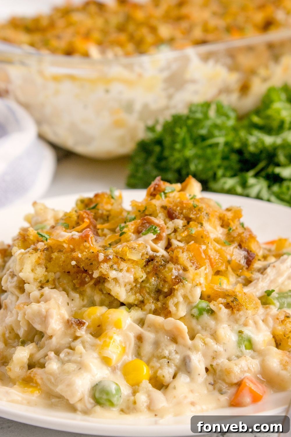 Savory Chicken Stuffing Bake 18 Chicken Stuffing Casserole on plate with a casserole dish in the background
