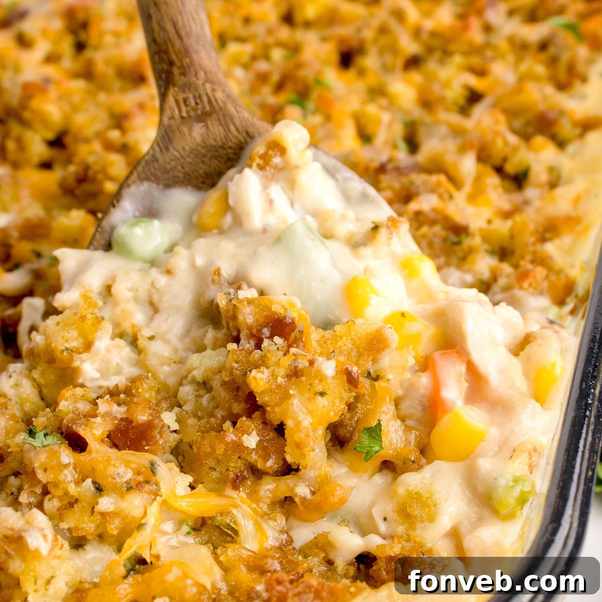 Savory Chicken Stuffing Bake 3 Chicken Stuffing Casserole in a pan with a wooden spoon scooping some of the casserole out of the pan