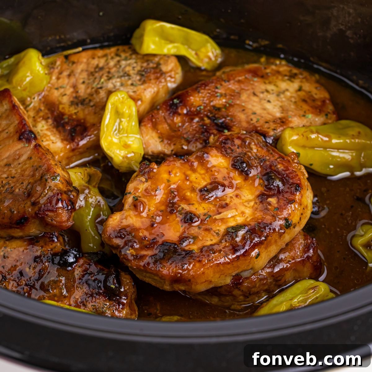 Crock Pot Mississippi Pork Chops in a crock pot with peppers on top of pork chops