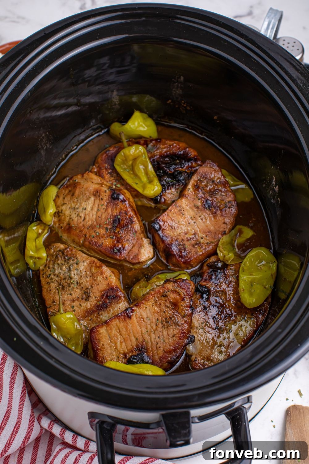 Crock Pot Mississippi Pork Chops - overhead look of pork chops and sauce in a slow cooker for crack pork chops