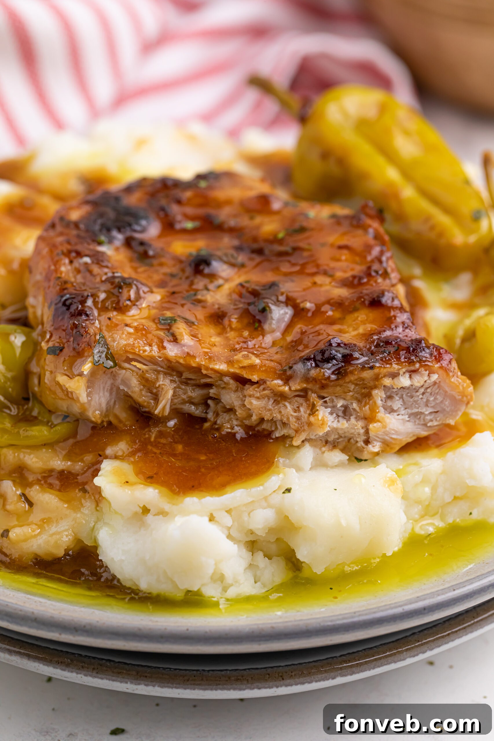 Mississippi pork chops over mashed potatoes on a white plate 