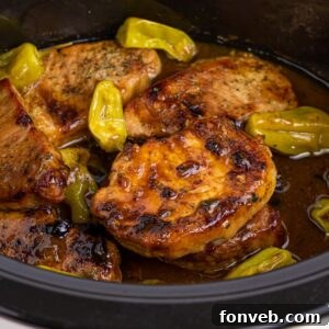 Crock Pot Mississippi Pork Chops in a crock pot with peppers on top of pork chops