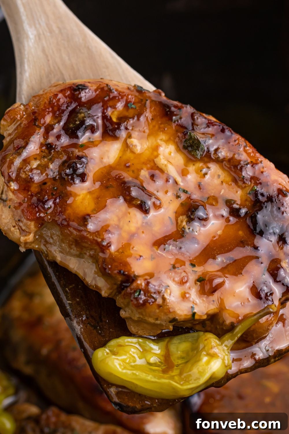 wooden spoon with pork chop and pepper on spoon