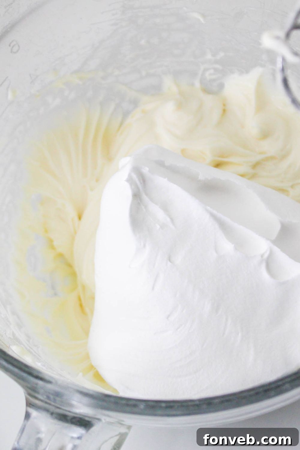 No Bake Strawberry Delight mixture in a bowl with whipped cream on top 