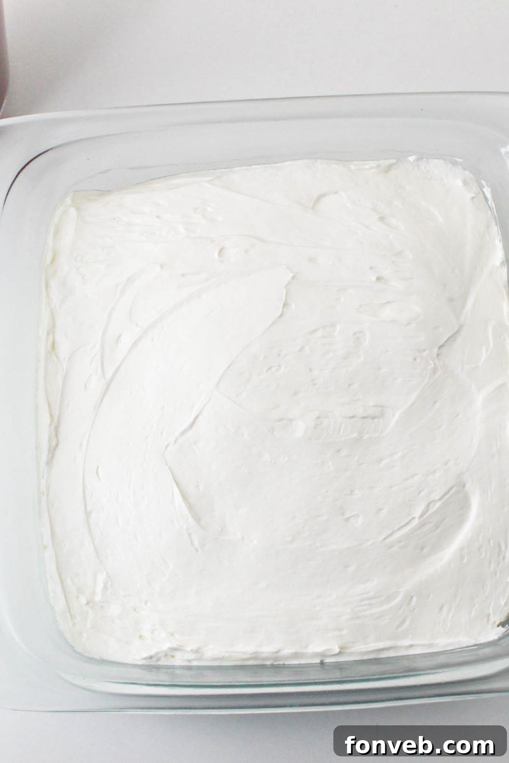 No Bake Strawberry Delight in pan with a whippd cream layer spread over the top